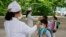 FILE - Kim Song Ju Primary school students have their temperatures checked before entering the school in Pyongyang, North Korea on June 3, 2020.