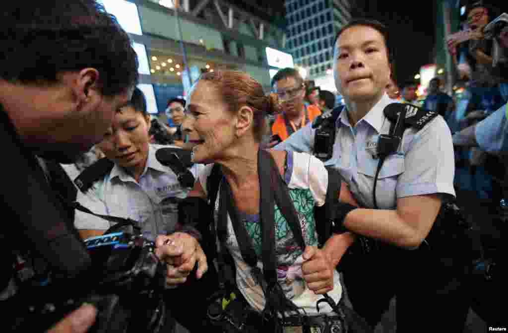 La policía detiene a la fotógrafa Paula Bronstein durante un enfrentamiento entre la policía y los manifestantes a favor de la democracia en el distrito comercial de Mongkok en Hong Kong el 17 de octubre de 2014.&nbsp;