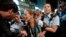 ARCHIVO - La policía detiene a la fotógrafa Paula Bronstein durante un enfrentamiento entre la policía y los manifestantes a favor de la democracia en el distrito comercial de Mongkok en Hong Kong en octubre de 2014. 