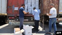 Customs officials inspect a convoy of humanitarian aid after it crossed into Syria from Turkey through the Bab al-Hawa border crossing, July 8, 2022.