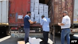 FILE - Customs officials inspect a convoy of humanitarian aid after it crossed into Syria from Turkey through the Bab al-Hawa border crossing, July 8, 2022.