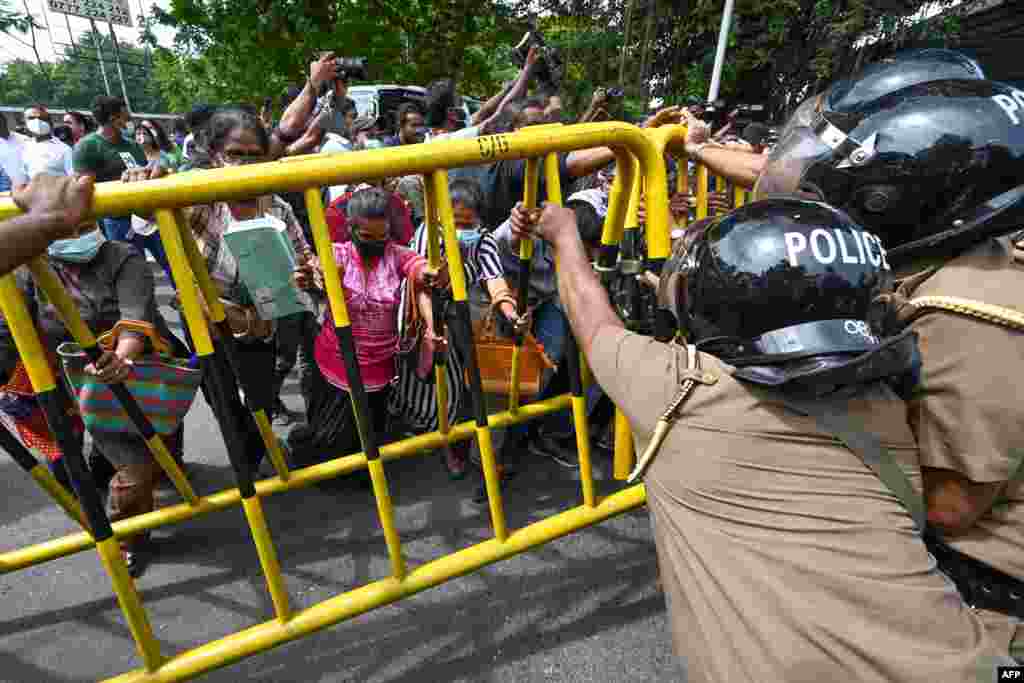 Activists from Samagi Vanitha Balawegaya, a part of the main opposition party Samagi Jana Balawegaya, overturn a police barricade during a protest outside Sri Lanka&#39;s Prime Minister Ranil Wickremesinghe&#39;s private residence in Colombo, amid the country&#39;s economic crisis.