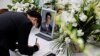 Seorang pelayat di depan foto mendiang mantan Perdana Menteri Jepang Shinzo Abe, yang tertembak saat berkampanye untuk pemilihan parlemen, di Tokyo, Jepang, 11 Juli 2022 (Foto: REUTERS/Issei Kato)