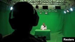 FILE - Ethiopian journalist Dessu Dulla, who works at the Oromia News Network, reads the news bulletin inside their studios in Addis Ababa, Ethiopia, May 25, 2021.