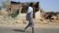 FILE - An Afari militia member walks next to a house destroyed in the fight between the Ethiopian National Defence Forces and the Tigray People's Liberation Front forces in Kasagita town, Afar region, Ethiopia, February 25, 2022. 