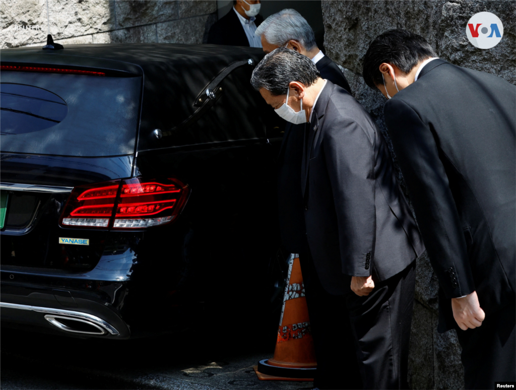 Funcionarios del PLD se inclinan ante el vehículo en el que se cree era llevado el cuerpo de Shinzo Abe.