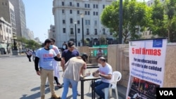 Ciudadanos recolectan firmas, el 19 de junio, en la plaza San Martín para presentar una demanda de inconstitucionalidad contra la ley aprobada en el Congreso sobre la reforma universitaria en Perú. [Foto: Rodrigo Chillitupa, VOA].