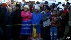 People stand behind a police cordon outside a nightclub in East London, South Africa, June 26, 2022. 