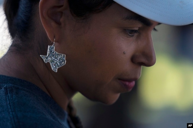 Ana Hernandez, a kindergarten teacher visiting from Dilley, Texas, wears an earring in the shape of Texas to show her support for the community. (AP Photo/Jae C. Hong)