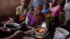 Des réfugiés de la RDC reçoivent un déjeuner au centre de transit de Nyakabande à Kisoro, en Ouganda, le 7 juin 2022.