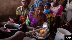 FILE: Refugees from the Democratic Republic of Congo (DRC) receive lunch at the Nyakabande Transit Center in Kisoro, Uganda, June 7, 2022, following deadly fights between M23 rebels, one of more than 120 armed groups roaming eastern DRC,