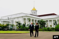 Presiden RI Joko Widodo (kanan) berjalan bersama Presiden Jerman Frank-Walter Steinmeier di Istana Kepresidenan RI di Bogor, 16 Juni 2022. (Handout / ISTANA PRESIDEN INDONESIA / AFP)