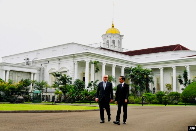 Presiden RI Joko Widodo (kanan) berjalan bersama Presiden Jerman Frank-Walter Steinmeier di Istana Kepresidenan RI di Bogor, 16 Juni 2022. (Handout / ISTANA PRESIDEN INDONESIA / AFP)