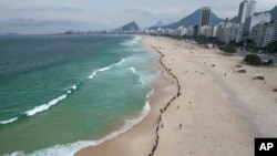 FILE - People create a line along Copacabana beach for a symbolic group hug with the sea on World Oceans Day in Rio de Janeiro, Brazil, June 8, 2022.