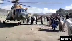 People carry injured to a helicopter following a massive earthquake, in Paktika Province, Afghanistan, June 22, 2022, in this screen grab taken from a video. (Bakhtar News Agency/Handout via Reuters)