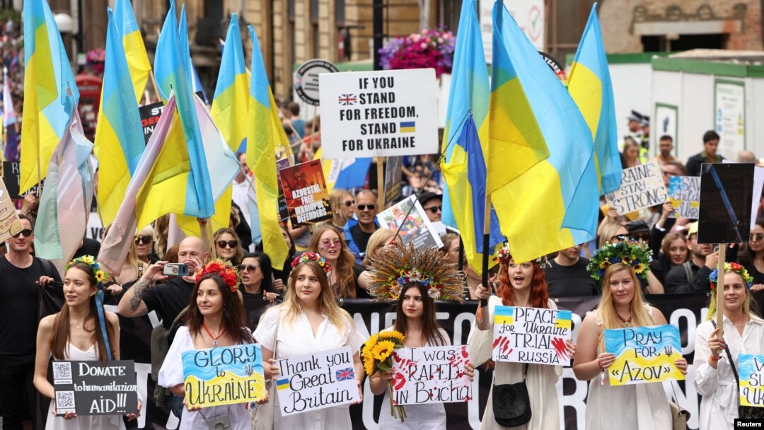 People hold Ukrainian flags and signs in support of Ukraine, as they take part in the 2022 Pride Parade in London, July 2, 2022.