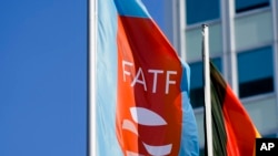 A flag with the logo of the Financial Action Task Force (FATF) waves in the wind next to the German national flag during a meeting of the group at the Congress Center in Berlin, June 17, 2022.