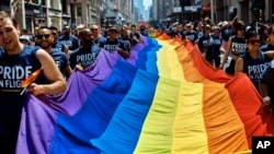 FILE - Reveler carry a LTBGQ flag along Fifth Avenue during the New York City Pride Parade on June 24, 2018, in New York. 