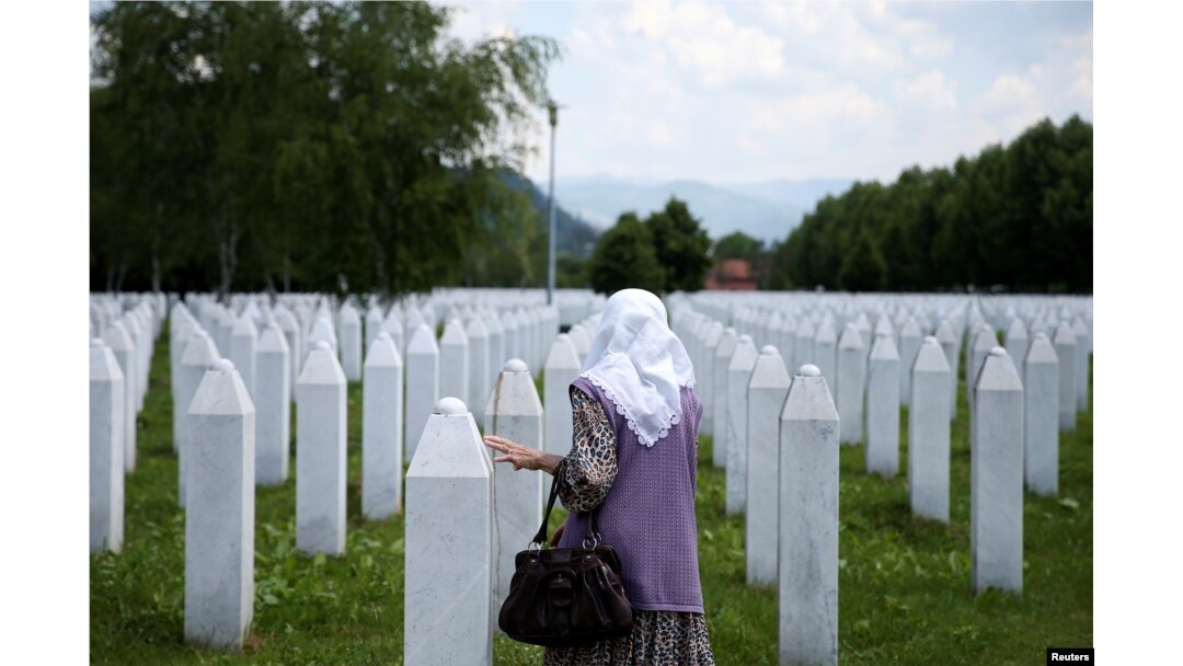Seorang perempuan Muslim Bosnia menyentuh batu nisan di Srebrenica Genocide Memorial di Potocari, Bosnia dan Herzegovina, 8 Juni 2021. (Foto: REUTERS/Dado Ruvic)