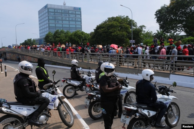 Police look on as Ghanaians march in the streets on the second day of protests over recent economic hardships, in Accra, Ghana, June 29, 2022.