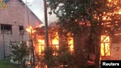 Fire burns in a building in the aftermath of shelling at a location given as Seredyna-Buda, Sumy region, Ukraine, in this screengrab obtained from a handout video released June 19, 2022. (State Emergency Service of Ukraine/Handout via Reuters)