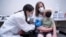 Pharmacist Kaitlin Harring, left, administers a Moderna COVID-19 vaccination to 3-year-old Fletcher Pack while he sits on the lap of his mother, McKenzie Pack, at Walgreens pharmacy Monday, June 20, 2022, in Lexington, South Carolina. 