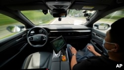 FILE - A technician monitors the self-driving taxi developed by tech giant Baidu Inc. on June 14, 2022, in Beijing, China. (AP Photo/Ng Han Guan)