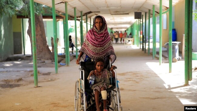 FILE - A woman brings her 7-year-old granddaughter for treatment at the Dubti referral hospital, Afar region, Ethiopia, Feb. 24, 2022.