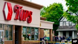 FILE - Investigators work the scene after a mass shooting at a supermarket, in Buffalo, N.Y., May 16, 2022.