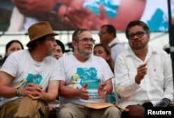 El líder rebelde de las FARC, Rodrigo Londoño, mejor conocido por su nombre de guerra Timochenko, al centro, hablan con el pastor Alape, a su izquierda, e Iván Márquez durante la ceremonia de clausura de un congreso rebelde cerca de El Diamante en los Llanos de Yari, Colombia, el 23 de septiembre de 2016.