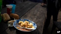 Un tazón de ravioles se sienta sobre una mesa de madera en un comedor social donde los residentes pueden obtener una comida gratis en el barrio Puerta de Hierro, en el distrito de La Matanza de Buenos Aires, Argentina, el 11 de mayo de 2022.