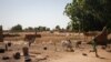 FILE - A child runs through destroyed houses in the village of Ogossagou, Mopti Region, Nov. 5, 2021.