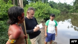 FILE - Veteran foreign correspondent Dom Phillips talks to two Indigenous men in Aldeia Maloca Papiú, Roraima state, Brazil, Nov. 16, 2019