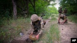 Soldiers of Ukraine's special operations unit lay anti-tank mines on a forest road on the Russian troops' potential way in the Donetsk region, Ukraine, June 14, 2022.