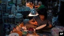 Staff members work at the Yuet Tung China Works, Hong Kong's last hand-painted porcelain factory, in Hong Kong, Wednesday, June 8, 2022. (AP Photo/Kin Cheung)