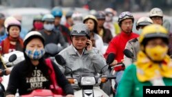 FILE - A motorist talks on his mobile phone while waiting at a traffic junction in Hanoi, Oct, 31, 2011. 
