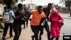 Protesters and passersby run from tear gas in Dakar, Senegal Friday, June 17, 2022. (Annika Hammerschlag/VOA)
