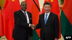 FILE - Malawi's then-President Arthur Peter Mutharika shakes hands with China's President Xi Jinping in Beijing, Sept. 1, 2018. China is working to protect its image in Africa after racist videos of African children made by a Chinese man living in Malawi surfaced this week.