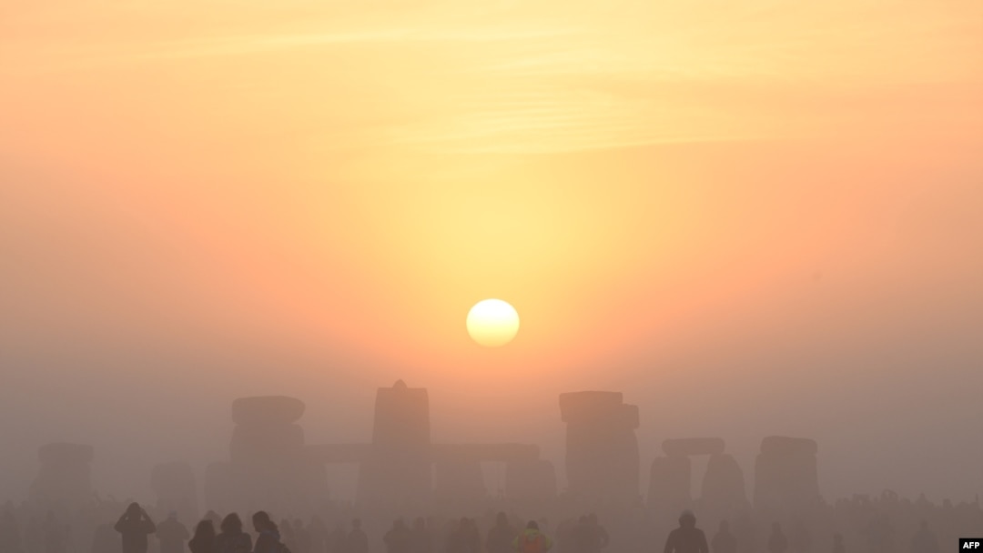 Para pengunjung merayakan "Titik Balik Matahari Musim Panas" saat matahari terbit di Stonehenge, di Wiltshire, Inggris selatan (21/6), dalam festival tradisional merayakan hari terpanjang dalam setahun di belahan bumi utara, ketika matahari berada pada ketinggian maksimumnya.