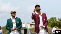 অ্যান্টিগা ও বারবুডার নর্থ সাউন্ডের ভিভিয়ান রিচার্ডস ক্রিকেট স্টেডিয়ামে বাংলাদেশ ও ওয়েস্ট ইন্ডিজের মধ্যকার প্রথম টেস্টের প্রথম দিনে ওয়েস্ট ইন্ডিজের ক্রেইগ ব্র্যাথওয়েট কয়েন টস করছেন।পেছনে দাঁড়িয়ে দেখছেন বাংলাদেশের সাকিব আল হাসান। ১৬ জুন ২০২২। 