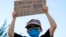 FILE - A boy holds a sign saying "All men are created equal," as he attends a protest on June 7, 2020, near the White House in Washington, over the death of George Floyd, a black man who was in police custody in Minneapolis. 