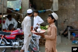 ARSIP - Seorang anak laki-laki Pakistan menghidangkan teh di sebuah kedai di Peshawar, Pakistan, Minggu, 12 Juni 2022. (Foto AP/Mohammad Sajjad, File)