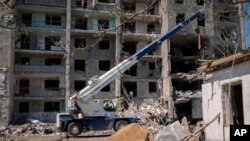 Ukrainian State Emergency Service firefighters clear debris at a damaged residential building in the town of Serhiivka, 50 kilometers southwest of Odesa, Ukraine, July 2, 2022.