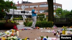 A woman reacts while visiting a memorial site after a mass shooting at a Fourth of July parade in the Chicago suburb of Highland Park, Illinois, July 6, 2022. 