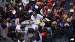 People displaced due to floods receive food at a temporary shelter in Sunamganj, Bangladesh, June 21, 2022.