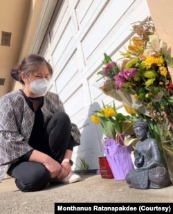 Monthanus Ratanapakdee sits and prays in front of the buddha statute and flowers at the San Francisco apartment building where her father (Vicha Ratanapakdee) was attacked in 2021; he later died of his injuries.