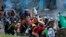 Protesters take cover behind makeshift shields during clashes with police in downtown Quito, Ecuador, June 24, 2022. The protesters are part of a national strike over economic issues, led by indigenous groups.