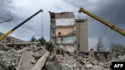 Rescuers clear the scene after a building was partially destroyed as a result of Russian missile hit on a four-story residential building in Chasiv Yar, Bakhmut District, eastern Ukraine, on July 10, 2022. 