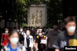 Sjumlah siswa berjalan keluar dari tempat ujian masuk universitas "gaokao" yang ditunda di kota karena wabah COVID-19, di Shanghai, China, 7 Juli 2022. (Foto: REUTERS/Aly Song )