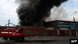 Firefighters work to control flames at the central market of Sloviansk on July 5, 2022, following a suspected missile attack. 